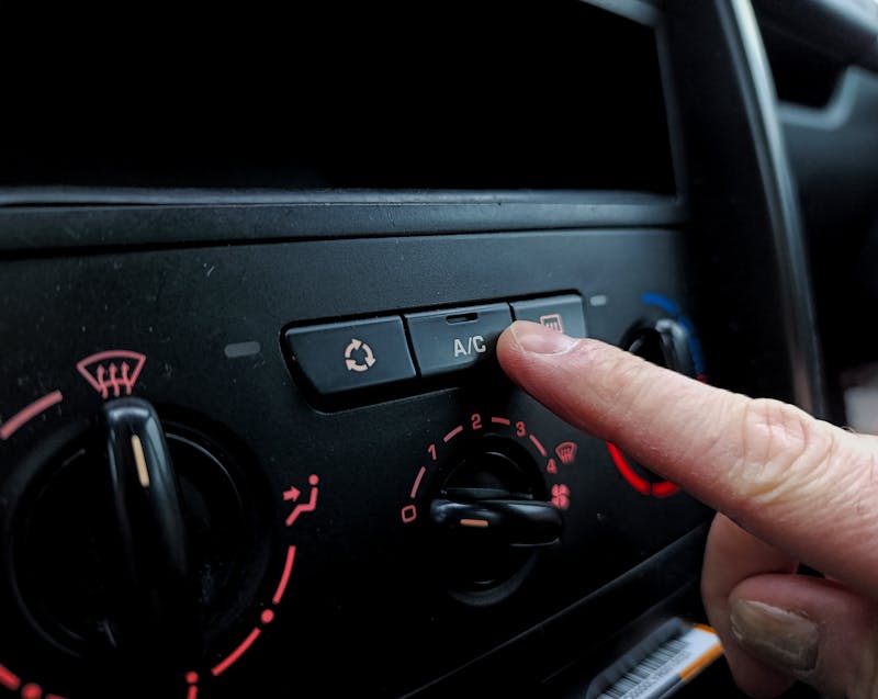 pressing the AC button on a car